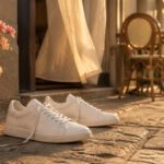 A collection of all white sneakers displayed on a neutral background.